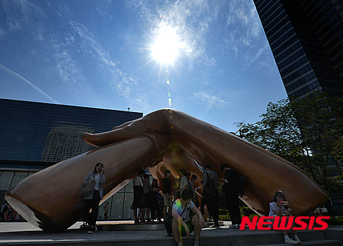 【서울=뉴시스】 박문호 기자 = 만물이 가득 찬다는 24절기 중 여덟 번째 절기 소만(小滿)인 20일 오후 서울 강남구 영동대로 코엑스 광장 조형물 아래 그늘에서 시민들이 더위를 피하고 있다. 이날 서울은 낮 최고 32도까지 오르며 올해 가장 더운 날씨를 보였다. 수도권에는 올해 첫 불볕더위주의보가 발효되고 전국 대부분 지역의 자외선 지수가 몇 분 내에도 피부에 화상을 입을 수 있는 '매우 높음' 단계를 보였다. 무더위와 강한 햇살은 주말까지 이어지겠다고 기상청은 전했다. 2016.05.20. go2@newsis.com