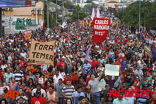 【상파울루=AP/뉴시스】 지우마 호세프 대통령의 복귀를 주장하며 미셰우 테메르 대통령권한대행의 퇴진을 요구하는 팻말을 든 시위대가 22일(현지시간) 상파울루시내에서 행진을 하고 있다. 2016.05.23&nbsp;&nbsp; 