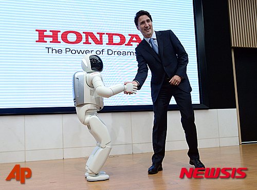 【도쿄=AP/뉴시스】일본을 방문한 저스틴 트뤼도 캐나다 총리가 24일 도쿄 혼다자동차 본사에서 로봇 아시모와 악수하고 있다. 2016.05.24 
