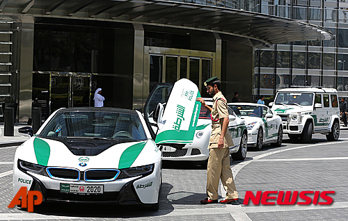 【두바이=AP/뉴시스】아랍에미리트연합 두바이에서 지난 19일(현지시간) 한 경찰이 14만달러(약 1억6551만원)짜리 BMW 경찰차에서 내려 문을 닫고 있다. 두바이 경찰은 지난 수년간 최고급 스포츠카와 SUV를 경찰차로 이용해오고 있다. 2016.05.26&nbsp; 
