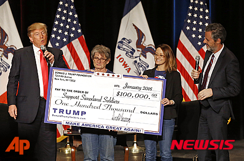 【AP/뉴시스】 지난 1월 31일 아이오와주 슈시티에서 도널드&nbsp; 트럼프 공화당 대선후보가 재향군인 돕기를 위한 성금을 전달하는 광경.&nbsp; 트럼프는 최근 그가 모금해온 재향군인 돕기 기부금을 어디에 썼느냐는 의혹과 함께 그의 부동산학교인 '트럼프대학교'가 직원들에게 값비싼 부동산강좌를 강매하도록 한 사실이 사기사건 집단소송 과정에서 드러나기도 했다. 2016.06.01&nbsp;&nbsp;&nbsp;&nbsp; 