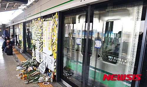 【서울=뉴시스】김선웅 기자 = 1일 오후 서울 광진구 구의역 스크린도어에 지난 28일 스크린도어 정비 작업 중 사망한 김 모(19) 씨를 추모하는 글이 붙어있는 너머로 전동차가 지나고 있다. 2016.06.01. mangusta@newsis.com