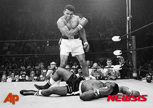 FILE - In this May 25, 1965, file photo, heavyweight champion Muhammad Ali, then known as Cassius Clay, stands over challenger Sonny Liston, shouting and gesturing shortly after dropping Liston with a short hard right to the jaw, in Lewiston, Maine. Ali, the magnificent heavyweight champion whose fast fists and irrepressible personality transcended sports and captivated the world, has died according to a statement released by his family Friday, June 3, 2016. He was 74. (AP Photo/John Rooney, File)