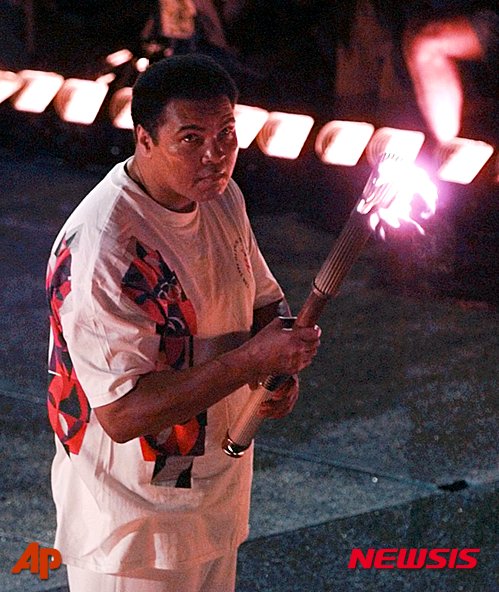 FILE - In this July 19, 1996, file photo, Muhammad Ali watches as the flame climbs up to the Olympic torch during the opening ceremonies of the Summer Olympics, in Atlanta. Ali, the magnificent heavyweight champion whose fast fists and irrepressible personality transcended sports and captivated the world, has died according to a statement released by his family Friday, June 3, 2016. He was 74. (AP Photo/Doug Mills, File)