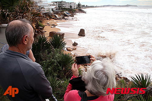 【콜라로이=AP/뉴시스】호주 뉴사우스웨일스, 빅토리아 주 등에서 지난 5일부터 최고 시속 125㎞의 강풍과 함께 집중호우가 이어져 최소 3명이 숨지는 등 피해가 속출하고 있다. 사진은 6일 시드니 외곽 콜라로이 해변에서 주민들이 거칠게 치는 파도를 바라보고 있는 모습. 2016.06.06