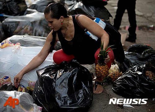 【카라카스=AP/뉴시스】베네수엘라 카라카스의 수퍼마켓 쓰레기장에서 지난 2일(현지시간) 한 여성이 먹을 만한 것을 찾기 위해 쓰레기를 뒤지고 있다. 2016.06.08