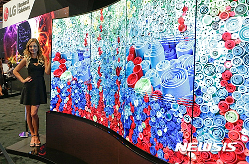 【서울=뉴시스】김진아 기자 = LG전자가 8일부터 사흘간 미국 라스베이거스에서 열리는 세계 최대 AV 전시회 ‘인포콤 2016(InfoComm 2016)’에 참가했다고 9일 전했다. LG전자는 300㎡ 규모의 전시부스를 마련해 차원이 다른 올레드 사이니지, 58:9 화면비로 공간 활용도를 높인 ‘울트라 스트레치’, 쉽고 직관적인 사이니지 플랫폼 ‘웹OS’를 적용한 솔루션 등 다양한 상업용 디스플레이 제품과 서비스를 선보였다. 사진은 모델이 LG전자 물결형 올레드 사이니지를 소개하고 있는 모습. 2016.06.09. (사진=LG전자 제공) photo@newsis.com