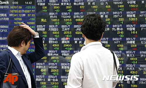 【도쿄=AP/뉴시스】 9일 일본 도쿄의 시민들이 한 증권사 전광판을 바라보고 있다. 이날 닛케이225지수(닛케이평균주가)가 전날보다 162.51포인트(0.97%) 하락한 1만 6668.41으로 마쳤다. 2016.06.09.