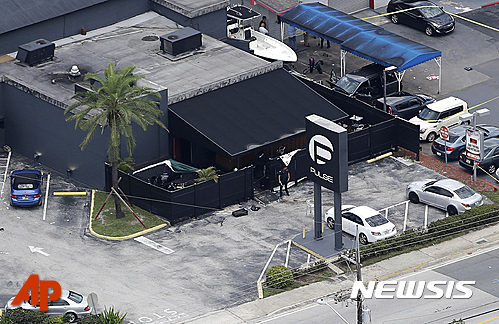 【올랜도=AP/뉴시스】미국 플로리다주 올랜도 펄스 나이트클럽에서 12일 (현지시간) 총기난사 사건이 마무리된 후 경찰 한 명이 입구에 서있다. 2016.06.13 