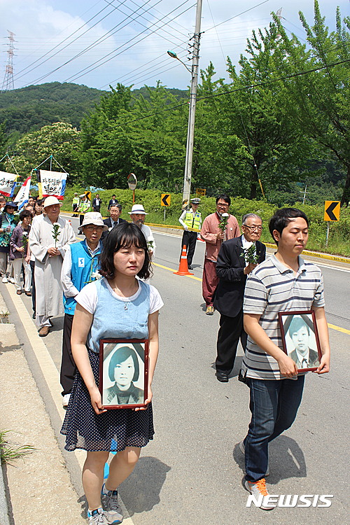 【양주=뉴시스】이종구 기자 = 미군 궤도차량에 치여 숨진 '고(故)신효순·심미선양'의 사망 14주기를 맞아 경기 양주시 두 여중생의 추모비에서 13일 진보단체 주관으로 추모제가 열렸다. 참석자들이 효순·미선 양의 영정사진을 들고 두 여학생이 살던 마을에서 사고 현장 추모비까지 행진하고 있다. 2016.6.13.&nbsp;&nbsp;&nbsp; leejg@newsis.com 