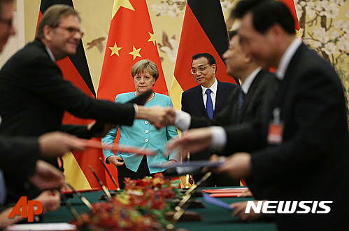 【베이징=AP/뉴시스】앙겔라 메르켈 독일 총리와 리커창 중국 총리가 13일 베이징 인민대회당에서 양국 대표단이 경제협력 조인서에 서명한 후 서로 악수하는 모습을 지켜보고 있다. 2016.06.13 