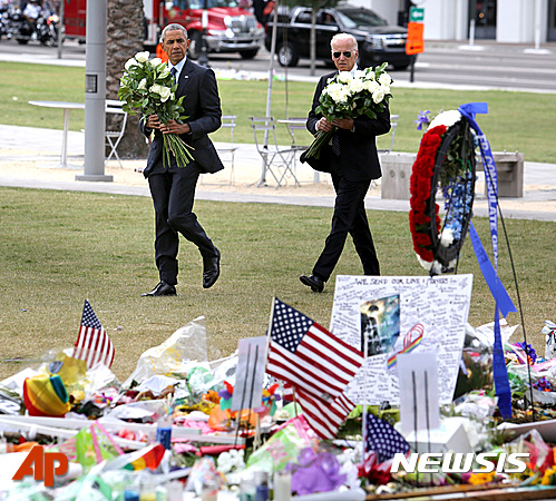 【올랜도=AP/뉴시스】버락 오바마 미국 대통령(왼쪽)과 조 바이든 부통령이 16일(현지시간) 플로리다주 올랜도를 방문해 총기난사 사건 희생자들을 추모하기 위해 꽃다발을 들고 추모장소 쪽으로 향해고 있다. 2016.06.17 