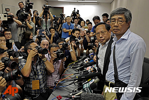 【홍콩=AP/뉴시스】지난해 10월 실종됐던 홍콩 반중 서적 판매 '통로완(銅鑼灣) 서점' 점장 람윙키(오른쪽)가 16일 홍콩에서 기자회견을 갖고 있다. 소식이 끊긴지 8개월만인 지난 14일 홍콩으로 돌아온 그는 기자회견에서 자신이 그간 중국 공안이나 국가안전부, 인민해방군이 아닌 '중앙 특별조사단'에 의해 부당하게 구속당한 경위 등을 폭로했다.2016.06.17