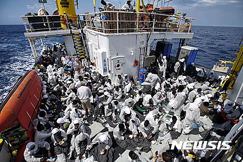【로마=AP/뉴시스】이탈리아 사법 당국이 4일(현지시간) 난민을 대상으로 인신매매, 장기매매를 저지르는 범죄조직을 급습해 38명을 체포하고 불법이민주선, 돈세탁, 마약 밀매 등의 협의로 기소했다고 밝혔다. 지중해에서 구조된 난민들이 지난 달 25일 아쿠아리우스호 뒤편에 타고 가고 있다. 2016.07.05 