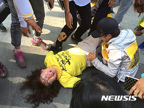 【서울=뉴시스】김선웅 기자 = 26일 오후 서울 종로구 정부서울청사 앞에서 세월호특별법 개정을 촉구하며 노숙농성을 벌이던 세월호 참사 유가족이 바닥에 쓰러진 채 항의하고 있다. 경찰과 종로구청은 이날 오후 도로통행에 지장을 준다는 이유로 설치된 차양막 등 시설물을 철거했으며 이 과정에서 경찰과 노숙농성에 참가한 유가족들이 경찰과 충돌해 유가족 2명이 경찰에 연행됐다. 2016.06.26. (사진=4.16 연대 제공) photo@newsis.com