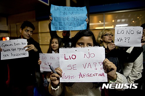 Fans of the Argentina national soccer team wait for players at the airport holding signs that read in Spanish "Lio is not leaving" Monday, June 27, 2016 in Buenos Aires, Argentina. Team star Lionel Messi says he's quitting Argentina's national team after loosing a final for the third year in a row, with Chile winning the Copa America 4-2 on penalty kicks following a 0-0 tie Sunday night. (AP Photo/Natacha Pisarenko)