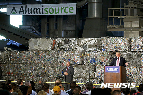 【모네센=AP/뉴시스】도널드 트럼프 미국 공화당 대선후보가 28일(현지시간) 펜실베이니아주 모네센 알루미늄 공장을 방문해 보호무역주의 강화 등에 대해 연설하고 있다.트럼프 뒤에 쌓여있는 것은 알루미늄 캔들을 압착한 것이다. 2016.06.29 
