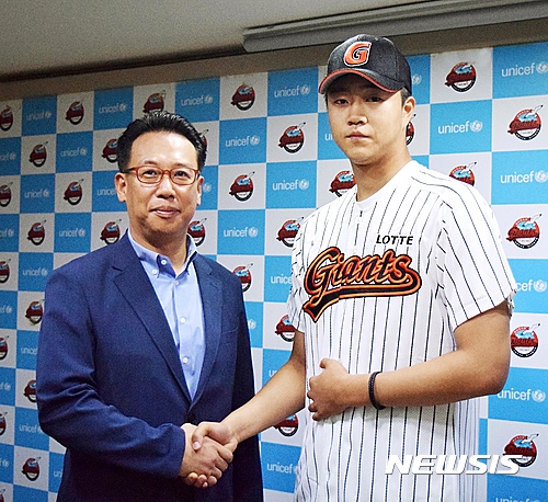 【서울=뉴시스】롯데 자이언츠가 부산고 3학년 투수 윤성빈(17)과 입단 계약을 체결했다. 윤성빈은 계약서에 사인을 한 뒤 롯데 이윤원 단장과 악수를 하고 있다. (사진 = 롯데 자이언츠 제공)