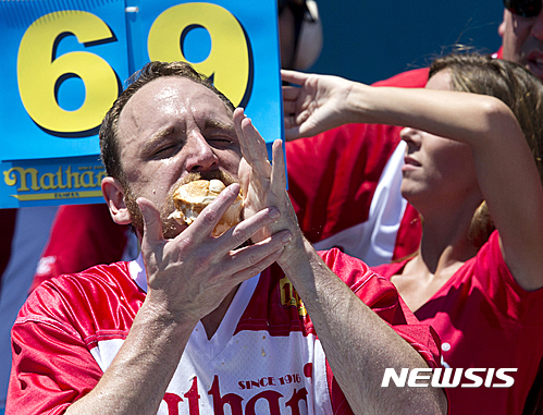 【뉴욕=AP/뉴시스】조이 체스트넛(32· 사진)가 4일(현지시간) 뉴욕 코니아일랜드에서 미국 독립기념일을 기념해 열린 핫도그 먹기대회에서 우승해 기뻐하고 있다. 체스트넛은 10분 동안 핫도그 70개를 먹어 치워 53개에 그친 전 챔피언 맷 스토니(24)를 꺾고 다시 한 번 챔피언에 올랐다.