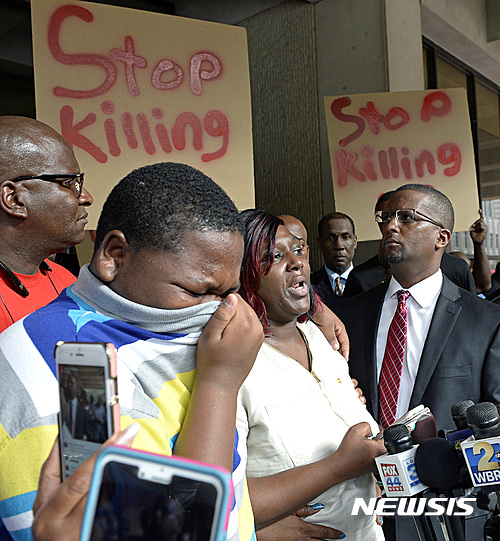 【배턴 루지=AP/뉴시스】백인 경찰이 쏜 총에 맞아 사망한 앨턴 스털링의 아들과 어머니가 6일(현지시간) 미국 루이지애나주 배턴 루지 시청 앞에서 시위를 벌이고 있다.지난 5일 배턴 루지의 한 편의점 앞에서 37살의 흑인 남성 앨턴 스털링이 백인 경관 두 명이 쏜 총에 맞아 사망한 사건이 발생하면서 미국 흑인 사회의 분노가 다시 폭발하면서 긴장이 고조되고 있다. 2016.7.7