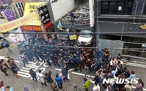 【서울=뉴시스】 박문호 기자 = 7일 오전 서울 신사동 가로수길 힙합듀오 '리쌍'이 소유한 건물에서 맘편히장사하고픈상인모임(맘상모) 등 시민단체 회원들이 임대 계약 문제로 마찰을 빚었던 곱창집 '우장창창'이 법원의 퇴거 강제집행을 막고 있다.&nbsp; 서 씨는 2010년 11월 현재 건물 1층에 곱창집을 개업했다. 1년 반 만에 건물주가 리쌍으로 바뀌며 서 씨는 리쌍 측으로부터 보증금과 1억8000만 원을 받고 건물 1층 주차장과 지하를 용도변경해 임대하는 조건으로 합의했다. 법원은 임대계약 종료 6개월에서 1개월 사이 건물주에게 계약 갱신 요구를 하지 않았다는 이유로 퇴거 명령을 내리고 지난 5월 30일 2차 퇴거명령 계고장의 기한이 지나 이날 새벽 6시께 강제집행을 진행했으나 가게에서 숙식하며 집행에 대비하던 서 씨와 맘상모 등 시민단체 회원들이 경비용역과 충돌해 10시께 강제집행을 멈추고 용역을 철수했다. 맘상모는 임대 계약을 일방적으로 해지하는 건물주에 맞서 상가 세입자들이 결성한 단체다. 2016.07.07.&nbsp; go2@newsis.com