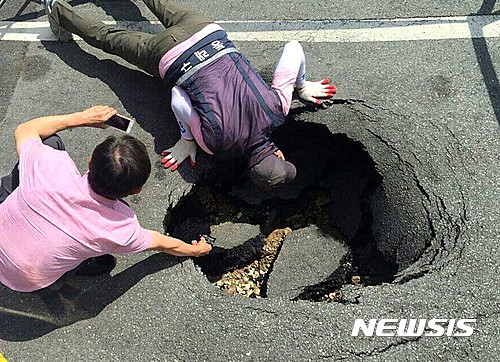 【부산=뉴시스】하경민 기자 = 7일 오후 1시 50분께 부산 동래구 모 은행 온천점 앞에서 가로·세로1ｍ, 깊이 2ｍ 크기의 싱크홀이 발생했다. 2016.07.07. (사진=동래경찰서 제공)&nbsp; yulnetphoto@newsis.com