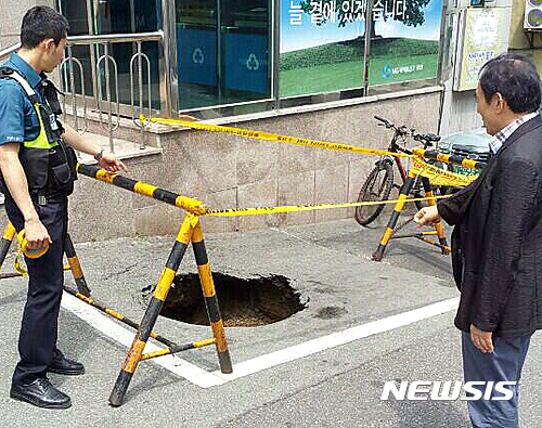 【부산=뉴시스】하경민 기자 = 7일 오후 1시 50분께 부산 동래구 모 은행 온천점 앞에서 가로·세로1ｍ, 깊이 2ｍ 크기의 싱크홀이 발생했다. 2016.07.07. (사진=동래경찰서 제공)&nbsp; yulnetphoto@newsis.com