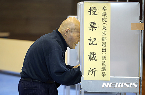 【도쿄=AP/뉴시스】10일 한 유권자가 일본 도쿄에 위치한 투표소에서 투표용지에 자신이 지지하는 의원 및 정당명을 적고 있다. 일본은 이날 121명의 참의원을 선출하기 위해 오전 7시 투표를 시작했다. 이날 투표는 오후 8시에 종료되며 11일 새벽께 정확한 집계 결과가 나올 예정이다. 이번 선거의 최대 쟁점은 아베 신조(安倍晋三) 총리가 목표하는 개헌에 찬성하는 자민당, 공명당 등 연립 여당과 오사카유신회, 일본의 마음을 소중히 하는 당 등 개헌파가 국회 발의에 필요한 3분의 2 의석을 확보할 수 있느냐는 것이다. 2016.07.10. 