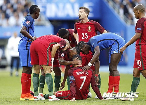 French and Portuguese players console Portugal's Cristiano Ronaldo after he got injured during the Euro 2016 final soccer match between Portugal and France at the Stade de France in Saint-Denis, north of Paris, Sunday, July 10, 2016. (AP Photo/Michael Probst)
