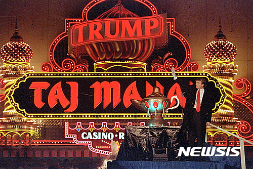 【어틀랜틱시티=AP/뉴시스】부동산 부호 도널드 트럼프가 1990년 4월 5일 뉴저지주 어틀랜틱시티에서 '트럼프 타지마할'카지노 개장식에 참석해 손을 흔들고 있다. 힐러리 클린턴 민주당 대선후보 진영은 트럼프가 개장한지 불과 1년만에 파산보호신청을 했던 '트럼프 타지마할'의 몰락과 관련해 자신의 책임을 거듭 축소하고 있다고 비판하고 있다. 2016.07.19&nbsp; 