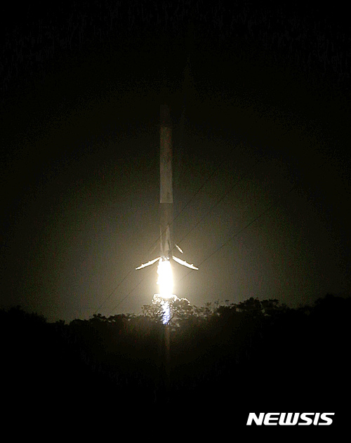 【케이프 커내버럴=AP/뉴시스】미국의 민간우주개발사 스페이스 X가 개발한 팰컨 9 로켓이 18일(현지시간) 플로리다주 케이프 커내버럴 미 공군기지에서 발사된 지 약 수 분 뒤 로켓 추진장치가 수직으로 재착륙하고 있다. 이로써 스페이스X는 지난해 12월에 이어 두번째로 지상에서 로켓 추진장치를 수직 착륙시키는데 성공했다. 스페이스 X는 회수한 장치를 로켓 발사에 재활용할 예정이다. 2016.07.18 