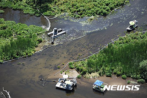 【AP/뉴시스】 = 지난 해 법원으로부터 6100만달러의 미 역사상 최고액 과징금을 선고받은 엔브리지 에너지 파트너스사의 원유 84만3000캘런 유출 사건으로 오염된 미시간주 마샬 부근의 강물 ( AP자료사진). 최근 미 연방연구소 과학자들은 수면의 오일만 흡착시키고 물은 빨아들이지 않아 쥐어짜면 기름을 회수할 수 있는 새 청소재료를 개발했다.