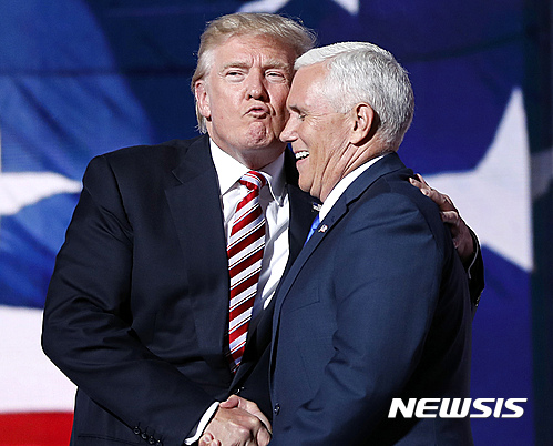 【클리블랜드=AP/뉴시스】미국 공화당 대선 후보 도널드 트럼프(왼쪽)와 부통령 후보 마이클 펜스 인디애나 주지사가 20일(현지시간) 오하이오주 클리블랜드의 전당대회장에서 인사하고 있다. 트럼프가 펜스의 부통령 후보 수락 연설 직후 그에게 다가가 포옹하며 키스하는 듯한 표정을 짓자 펜스가 환하게 웃고 있다. 2016.7.21. 