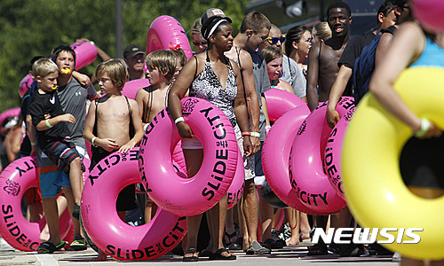 【포트워스=AP/뉴시스】 미국 전역에 폭염과 높은 습도가 계속되면서 23일(현지시간) 주말을 맞아 텍사스주 포트워스의 산 위에 있는 클리어포크 메인 스트리트의 물놀이 미끄럼틀 앞에 사람들이 몰려 장사진을 이루고 있다. 2016.07.24