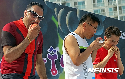 【옥천=뉴시스】이성기 기자 = 24일 충북 옥천에서 열린 '10회 향수옥천 포도·복숭아 축제'에서 복숭아 빨리먹기 대회에 참가한 한 외국인이 복숭아를 먹고 있다.2016.07.24(사진=옥천군 제공) sklee@newsis.com