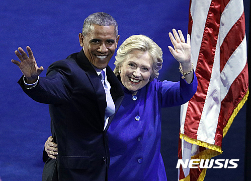 【필라델피아=AP/뉴시스】버락 오바마 미국 대통령이 27일(현지시간) 펜실베이니아주 필라델피아에서 열린 민주당 전당대회에서 장시간에 걸쳐 격정적인 연설을 마친 후 무대에 감짝 등장한 힐러리 클린턴 민주당 대선후보와 함께 손을 흔들고 있다. 두 사람은 8년전 민주당 대선 경선과정에서 경쟁자로 싸운 적이 있으며, 당시 클린턴은 오바마에 대한 지지를 선언하고 후보 사퇴를 했었다. 2016.07.28 