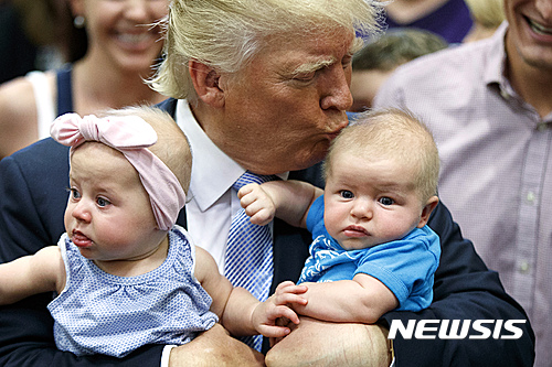 【콜로라도스프링스=AP/뉴시스】미국 공화당 대선 후보 도널드 트럼프가 29일(현지시간) 콜로라도주 콜로라도스프링스에서 선거 유세를 했다. 사진은 트럼프가 지지자의 아기들을 안고 키스하는 모습. 2016.7.31.