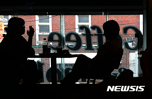 【서울=뉴시스】조성봉 기자 = 1일 오후 서울 도심의 한 흡연카페에서 흡연자들이 커피를 마시며 담배를 피우고 있다.&nbsp; 흡연카페는 휴게음식점이 아닌 식품 자동판매기 업소로 등록해 영업을 하고 있으며, 탁자나 의자가 있지만 '서빙'을 하지 않고 셀프로 커피를 타 마시도록 하고 있다.&nbsp; 복지부는 흡연카페 15곳 가운데 연면적 1,000㎡ 이상인 건물에 있는 5곳에 대해서 폐업이나 업종 변경을 권고했지만 연면적 1,000㎡ 미만인 건물에 있는 흡연카페는 단속할 근거가 없다. 2016.08.01. suncho21@newsis.com