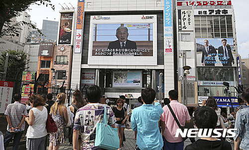 【도쿄=AP/뉴시스】일본 도쿄 시민들이 8일 가던 발길을 멈추고, 아키히토 일왕이 조기퇴위 의사를 밝히는 영상을 바라보고 있다. 2016.08.08  