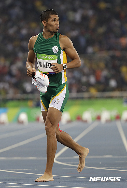 【리우데자네이루=AP/뉴시스】남아공의 웨이드 판 니케르크(24)가 15일(한국시간) 리우데자네이루 마라카낭 올림픽주경기장에서 열린 남자 육상 400m에서 43초03을 기록, 17년 만에 종전 세계기록을 경신한 뒤 맨발로 트랙을 돌고 있다. 그의 기록은 지난 1999년 세비야세계선수권대회에서 마이클 존슨(49· 미국)이 기록한 종전 기록을 0.15초 단축한 세계신기록이다. 