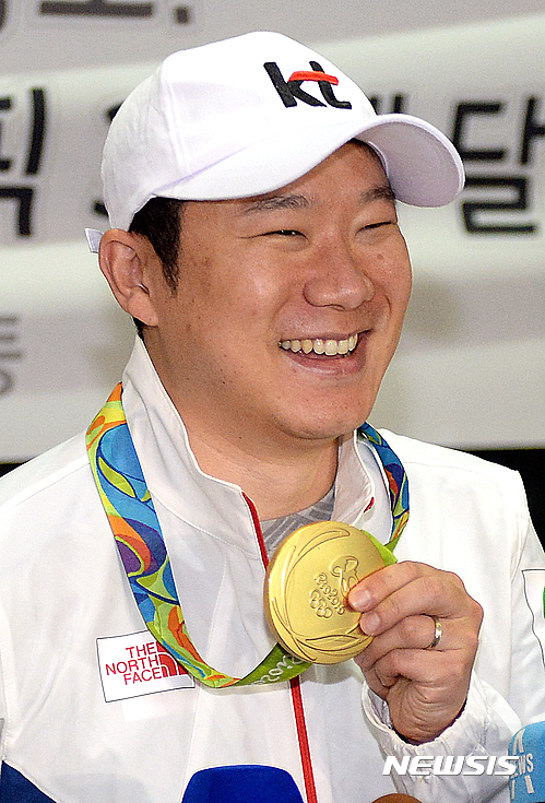 【인천공항=뉴시스】최진석 기자 = 사격 남자 50m 권총 금메달을 따며 올림픽 3연패를 차지한 진종오가 17일 인천국제공항을 통해 2016 리우 올림픽 일정을 마치고 귀국해 인터뷰하며 금메달을 들어 보이고 있다. 2016.08.17.&nbsp; myjs@newsis.com