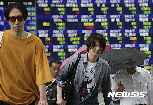 【도쿄=AP/뉴시스】18일 일본 닛케이225지수(닛케이평균주가)는 엔화 강세로 전일 대비 259.63포인트(1.55％) 하락한 1만 6486.01에 마감했다. 사진은 이날 도쿄의 한 증권사 전광판 앞을 걷고 있는 시민들의 모습.2016.08.18. 