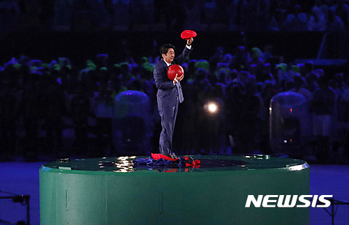 【리우데자네이루(브라질)=AP/뉴시스】 2016년 8월22일(한국시각) 브라질 리우 마라카낭 주경기장에서 열린 2016 리우데자이네루 올림픽 폐막식에서 다음 개최지인 일본의 아베 신조 당시 총리가 게임 슈퍼마리오 모자를 쓰고 나타나 인사하고 있다. 2021.07.21.