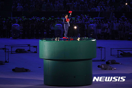 【리우데자네이루(브라질)=AP/뉴시스】 22일(한국시각) 브라질 리우 마라카낭 주경기장에서 열린 2016 리우데자이네루 올림픽 폐막식에서 다음 개최지인 일본의 아베 신조 총리가 게임 슈퍼마리오 모자를 쓰고 나타나 인사하고 있다. 2년 뒤인 2018년에는 강원도 평창에서 동계올림픽이 펼쳐지며 2020년 하계올림픽은 일본 도쿄에서 펼쳐진다. 2016.08.22.