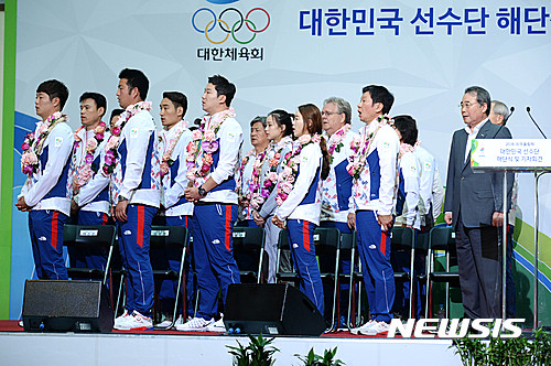 【인천공항=뉴시스】 박문호 기자 = 강영중(앞줄 오른쪽부터) 대한체육회 회장과 정몽규 한국선수단 단장, 양궁 국가대표 장혜진 등 참석자들이 24일 오전 인천 중구 공항로 인천국제공항에서 열린 2016 리우데자이네루 올림픽 한국선수단 해단식에서 국민의례를 하고 있다. 2016.08.24. go2@newsis.com