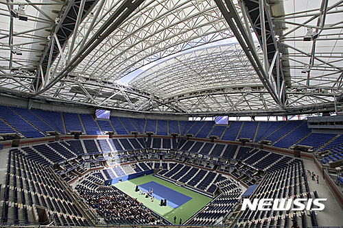 FILE - In this Aug. 2, 2016, file photo, the partially open new retractable roof allows a ribbon of light into Arthur Ashe Stadium at the Billie Jean King National Tennis Center, in the Queens borough of New York. The first round of the U.S. Open tennis tournament is scheduled for Monday, Aug. 29. (AP Photo/Richard Drew, File)