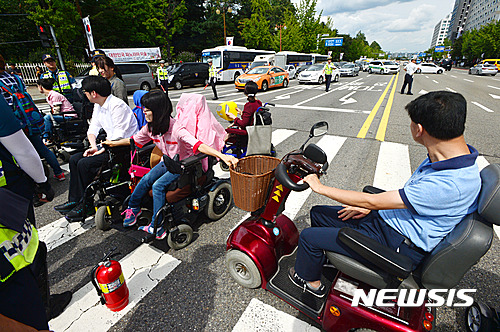 【서울=뉴시스】배훈식 기자 = 한국장애인자립생활센터총연합회 회원들이 29일 오후 서울 여의도 국회대로를 점거하고 활동보조인 수가 인상을 촉구하고 있다. 2016.08.29. dahora83@newsis.com
