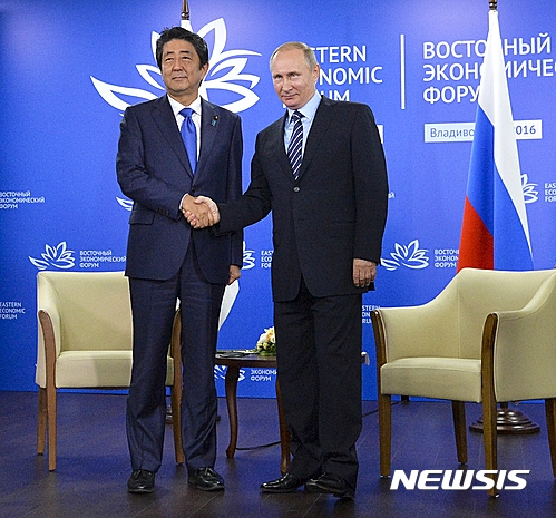 【블라디보스톡=AP/뉴시스】아베 신조 일본 총리(왼쪽)와 블라디미르 푸틴 러시아 대통령이 2일(현지시간) 동방경제포럼이 열리는 러시아 블라디보스톡에서 만나 악수하고 있다. 2016.09.02 