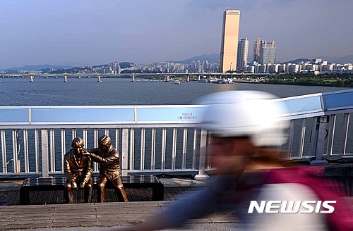 [서울=뉴시스]전신 기자 = 서울 마포대교에 설치된 '한번만 더' 동상 앞을 시민들이 지나고 있는 모습. 2016.09.09 photo1006@newsis.com