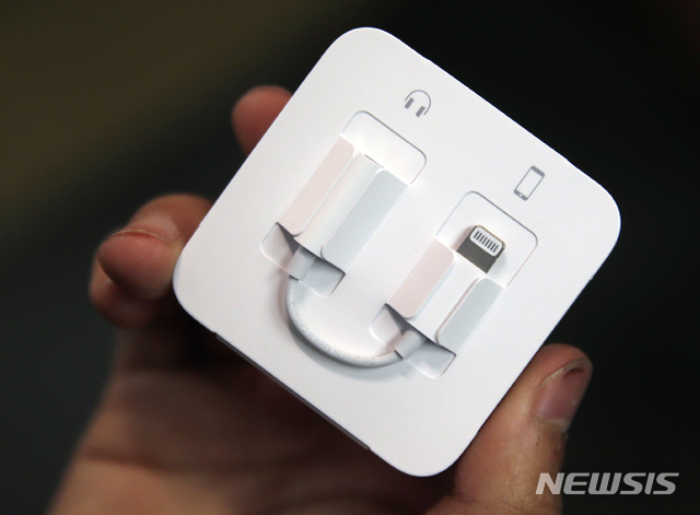 [시카고=AP/뉴시스] 2016년 미국 시카고의 한 소비자가 애플 라이트닝 케이블과 연결되는 이어폰을 들고 있는 모습. 2020.1.31.